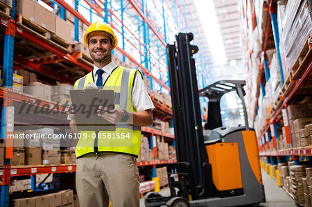 Smiling warehouse manager with clipboard