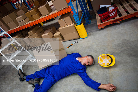 High angle view of unconscious worker lying on the floor