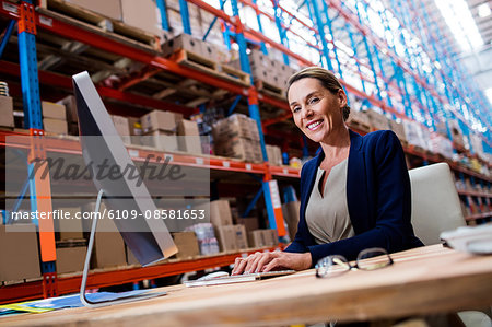 Warehouse manager using a laptop