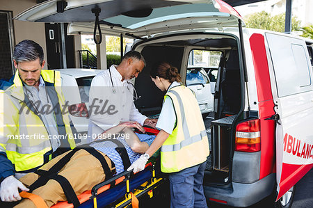 Ambulancemen carrying injured man on a stretcher