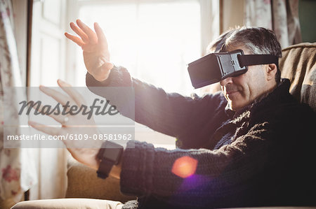 Side view of man using smart glasses while sitting