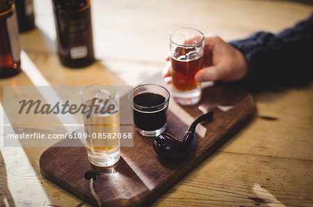 Cropped image of mature man taking a glass of alcohol