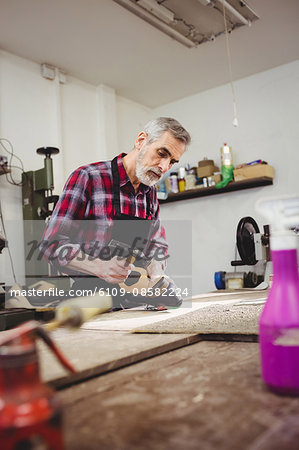 Cobbler hammering on the heel of a shoe