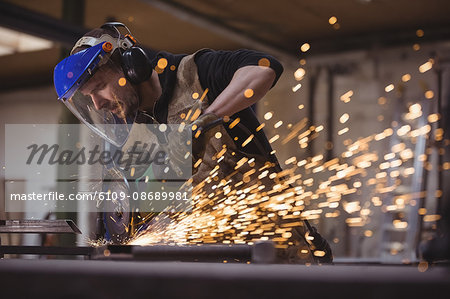 Welder working with machine in the workshop