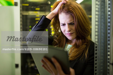 Technician using digital tablet in server room Technician using digital tablet in server room