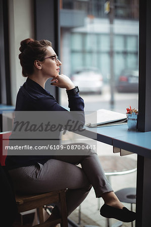 Businesswoman sitting by table in cafe