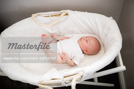 baby sleeping in moses basket