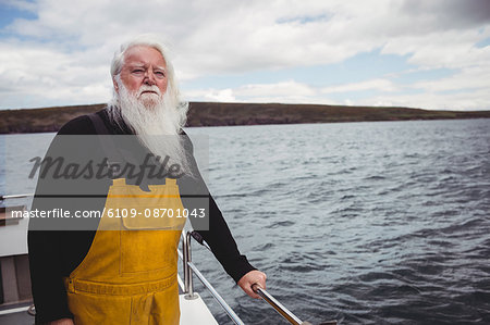 Thoughtful fisherman looking at view from fishing boat