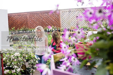 Florist talking to women buying a plant in a garden centre