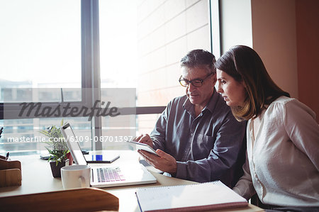 Man and woman discussing over digital tablet in the office