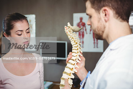 Physiotherapist explaining the spine to female patient in the clinic