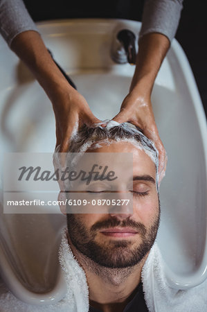 Smiling man getting his hair wash at a salon