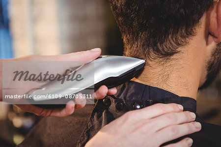 Man getting his hair trimmed with trimmer in salon