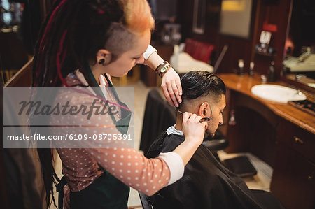 Man getting his hair trimmed with razor in barber shop