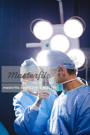 Smiling surgeons interacting in operation room at hospital