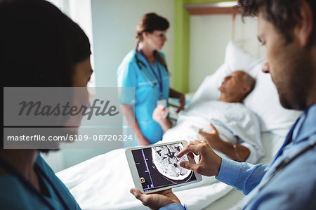 Male doctor and nurse using digital tablet in hospital