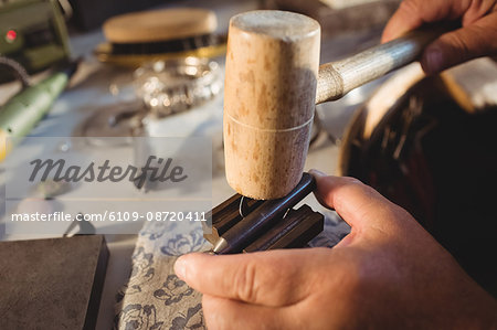 Close-up of goldsmith preparing ring in workshop