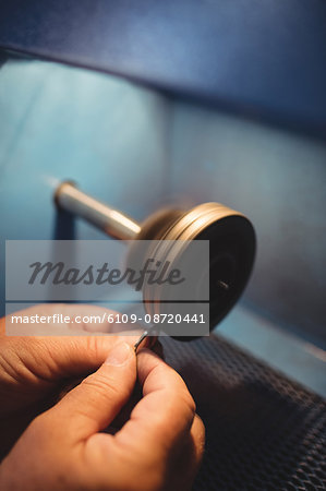 Close-up of goldsmith polishing ring in workshop