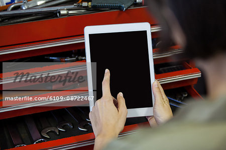 Mechanic using digital tablet at the repair garage