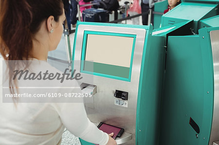 Traveller using self service check-in machine at airport