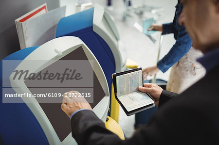 Businessman using self service check-in machine at airport