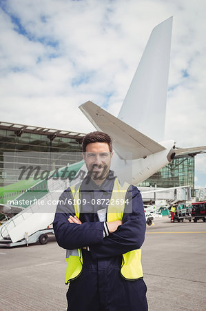 Portrait of airport ground crew standing on runway at airport terminal