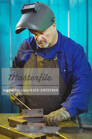 Male welder working on a piece of metal in workshop