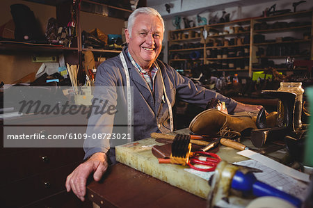 Portrait of shoemaker standing in workshop in workshop