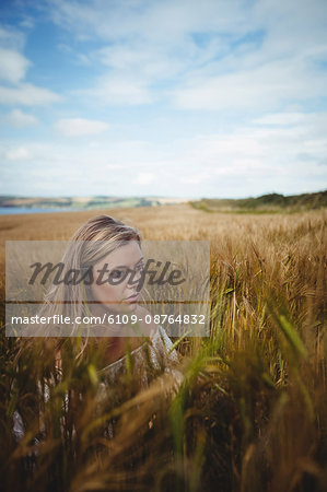 Woman touching wheat crop in field on a sunny day