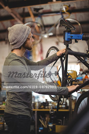 Mechanic examining a bicycle in bicycle workshop