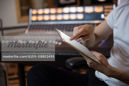 Hands of a person using digital tablet in recording studio