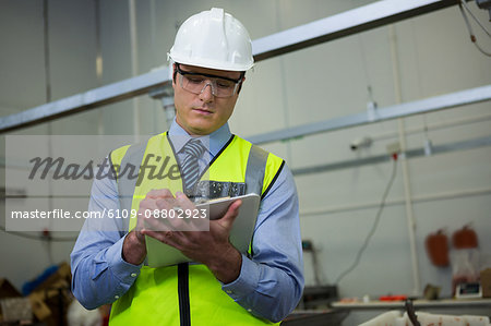 Technician writing on a clipboard at meat factory