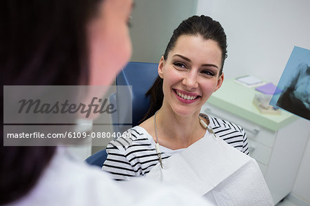 Female patient smiling while talking to doctor at clinic