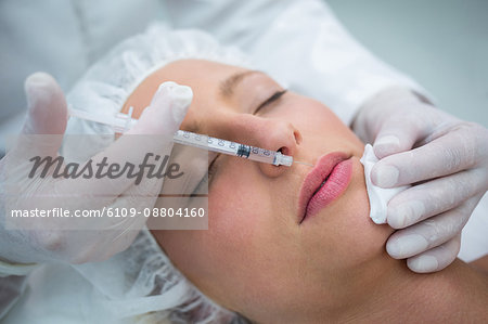 Close-up of female patient receiving a botox injection on lips
