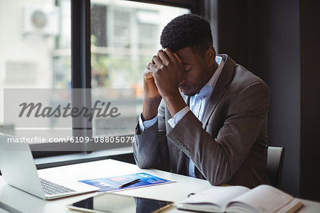 Stressed businessman sitting at his desk in office