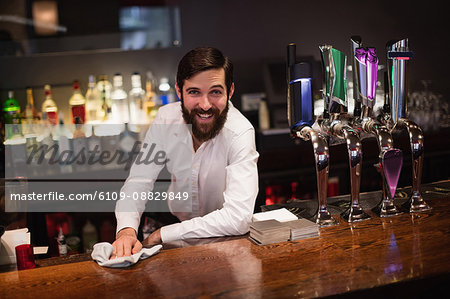 Bartender Standing at Bar Counter, Cleaning Glasses with Towel Stock Photo  - Image of portrait, informal: 190411966