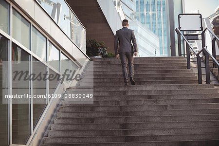 Businessman with a diary climbs up stairs