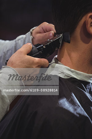 Close Up Of Man Getting His Hair Trimmed With Trimmer In Barber