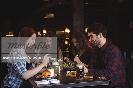 Happy friends enjoying food in bar