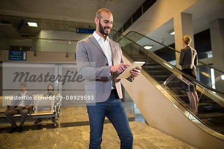 Businessman using digital tablet at airport