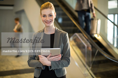 Portrait of businesswoman holding digital tablet at airport
