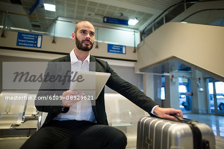 Businessman using digital tablet at airport