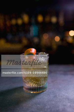 Close up of orange cocktail in glass at counter in bar