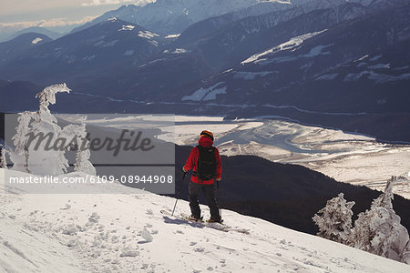 Rear view of skier skiing in snowy alps during winter