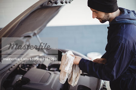 Hand of mechanic servicing car with a tool