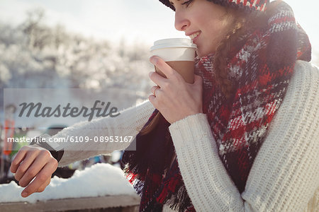 Woman skier watching her smartwatch while having coffee