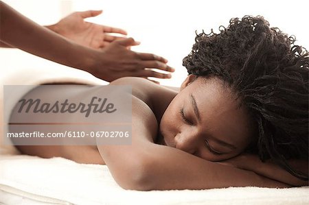 https://image1.masterfile.com/getImage/6110-06702706em-young-black-woman-in-a-salon-receiving-a-back-massage-stock-photo.jpg