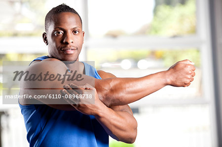 Male Bodybuilder Flexing His Muscle In Gym Stock Photo, Picture