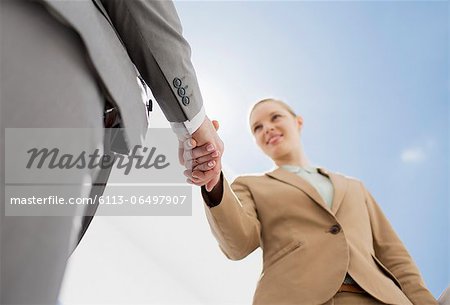 Smiling businesswoman shaking businessman's hand