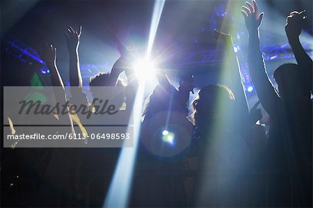 Spotlight over crowd dancing on dance floor